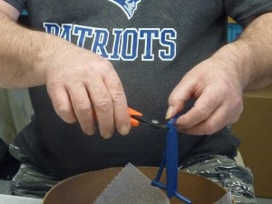 Gate Cutters as demonstrated by an operator trimming injectiion molded parts free from the gate